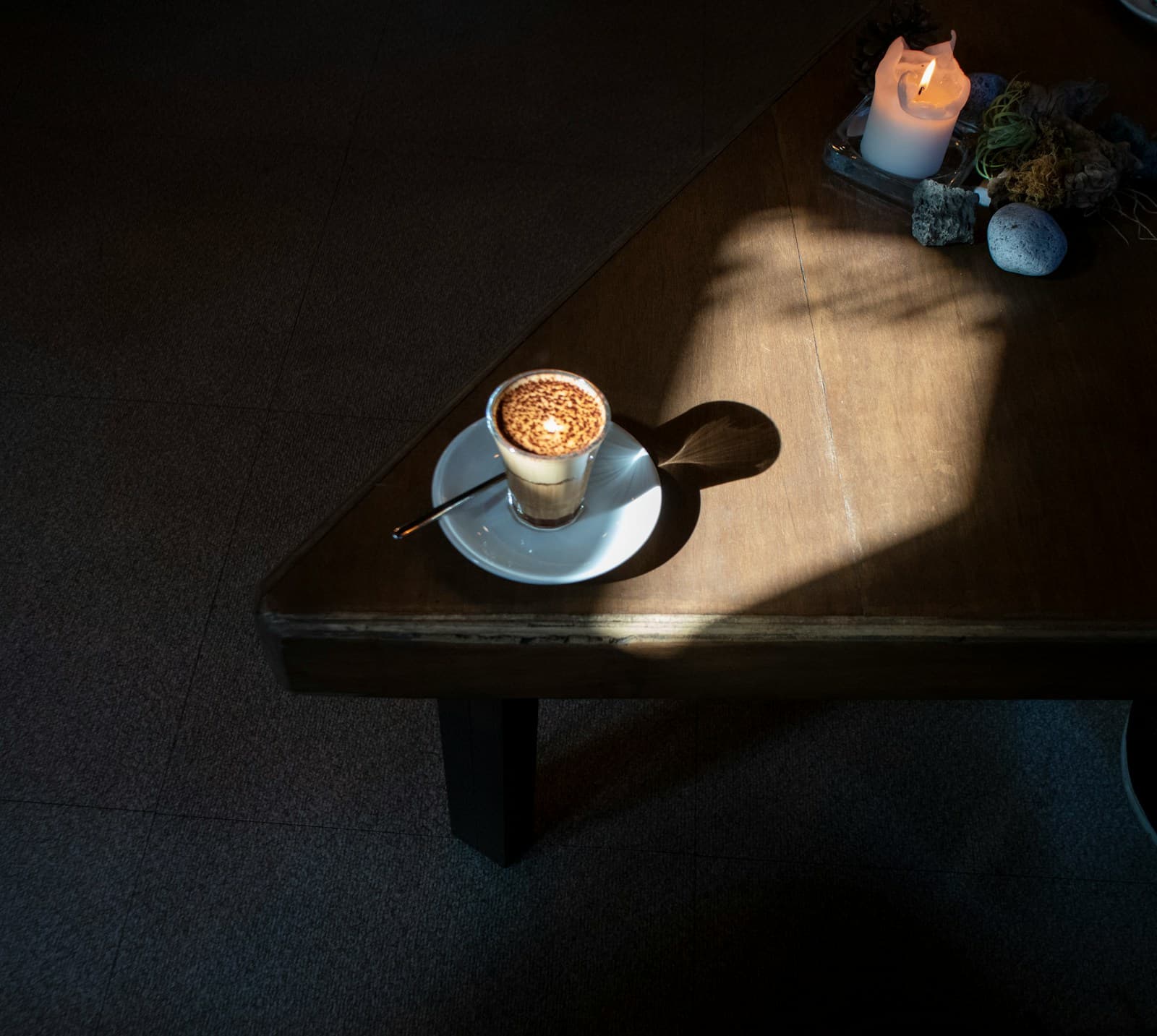 Coffee and candle on a wooden table.